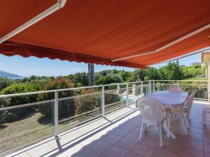 a patio with a table and chairs on a balcony at Modern villa with private pool in Santʼ Andrea-dʼOrcino