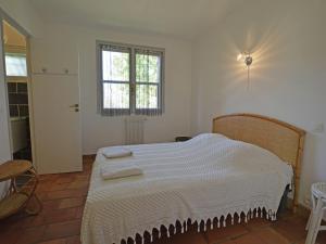 a bedroom with a bed with white sheets and a window at Pretty house 30 minutes from the beach in Vergèze