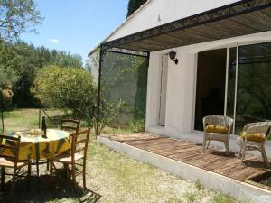 a patio with a table and chairs on a deck at Pretty house 30 minutes from the beach in Vergèze