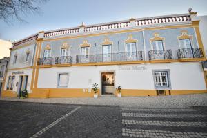 um grande edifício amarelo e branco com uma varanda em Hospedaria Dona Maria em Beja