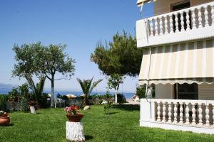 a house with a yard with flowers in the grass at Posidonia Pension in Amarynthos