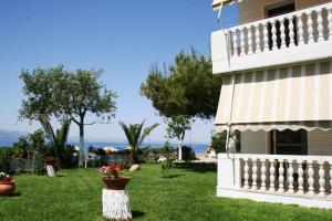 una casa con un patio con flores en el césped en Posidonia Pension, en Amarinto