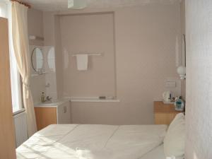
a hotel room with a bed and a mirror at Invernook in Newquay
