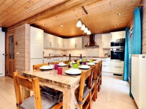 a large kitchen with a wooden table and chairs at Atmospheric chalet with sauna and jacuzzi in Septon