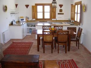 a kitchen with a wooden table and chairs in a room at Holiday Home Finca Retama in Ronda