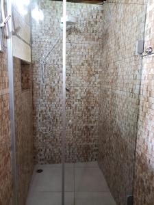 uma casa de banho com um chuveiro e uma porta de vidro em POUSADA TRUFFIMAR reservas Ilhabela em Ilhabela