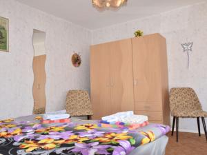 キュールングスボルンにあるCozy Bungalow in Kuhlungsborn-West near Beachのベッドルーム1室(ベッド1台、椅子2脚、キャビネット付)