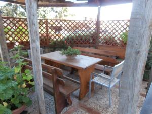 a wooden table and chairs and a table and a bench at Busalacchi B&B in Mondello