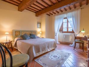 Schlafzimmer mit einem Bett, einem Schreibtisch und einem Fenster in der Unterkunft Belvilla by OYO Gaville 8 in Figline Valdarno