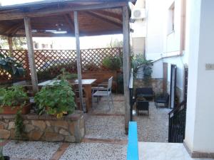 a pergola with a table and chairs in a patio at Busalacchi B&B in Mondello