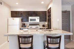 a kitchen with a white refrigerator and a counter at Value Suites Extended Stay - Arlington in Arlington