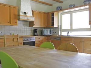a kitchen with wooden cabinets and a table and a window at Modern Apartment in H ddingen with Terrace in Bad Wildungen