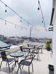 a patio with tables and chairs on a roof at Puri Maju Hotel in Jakarta