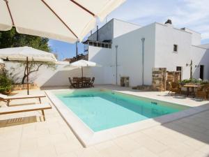 uma piscina com cadeiras e guarda-sóis ao lado de uma casa em Villa consisting of 5 apartments with swimming pool, near center, sea 6 km em Racale