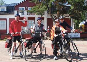 a group of people riding bikes on a street at Hotel Strandbo in Nauvo