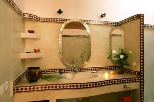 a bathroom with a large mirror and a sink at Riad Soumia in Marrakesh