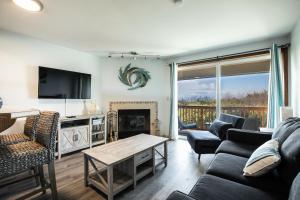 a living room with a couch and a fireplace at Calypso at Nautilus - Pet Friendly, Walk to beach! in Ocean Shores