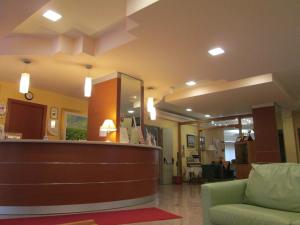 una hall ospedaliera con bancone della reception e divano verde di Hotel Due Pini a Melfi