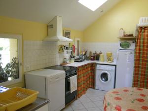 een keuken met een wasmachine en een wasmachine bij Pleasant holiday home with garden in Isigny-le-Buat