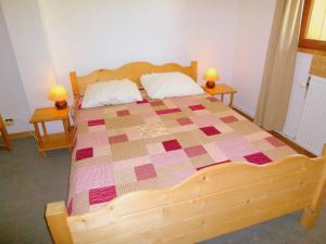 1 dormitorio con cama de madera y edredón en The ideal chalet for a relaxing holiday in the mountains en Celliers