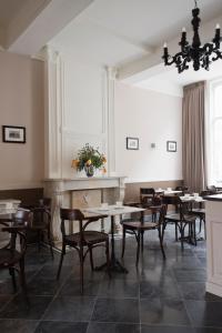 a dining room with tables and chairs and a fireplace at Boutique hotel Sint Jacob in Maastricht