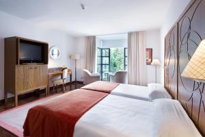 a hotel room with a large bed and a desk at Parador de Limpias in Limpias