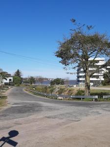 een lege weg met een boom en een gebouw bij Loft del barranco in Colonia del Sacramento