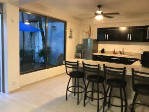 a kitchen with black bar stools and a counter at blue angel 1 aunos pasos de la 5 av in Playa del Carmen