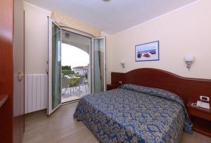 a hotel room with a bed and a balcony at Residence Costa Smeralda in Grottammare