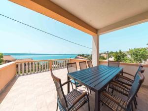 una mesa y sillas en un balcón con vistas al océano en Capacious Holiday Home in Maslenica, en Maslenica