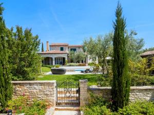 a house with a gate in a garden at Lush Villa with Artistic Interiors Pool in Baderna