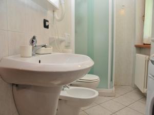 a white bathroom with a sink and a toilet at Belvilla by OYO GrBe Bilo in Antey-Saint-André