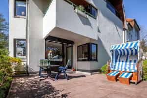 a patio with a table and two chairs in front of a house at Strand-Park in Travemünde