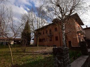 an old brick house with a tree in front of it at Belvilla by OYO La Torre in Belvedere Langhe