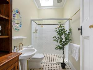 a bathroom with a sink and a toilet and a shower at Lilly Pilly Arthouse in Stanwell Park