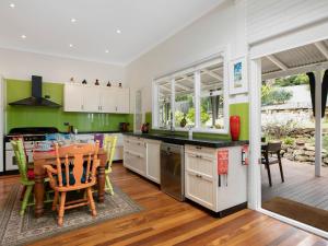 a kitchen with a table and a dining room at Lilly Pilly Arthouse in Stanwell Park