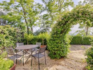 タヴァルネッレ・ヴァル・ディ・ペーザにあるCozy Holiday Home in Tavarnelle Val di Pesa with Shared Poolの縞のある庭園のテーブルと椅子