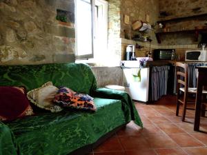 uma sala de estar com um sofá verde e uma cozinha em Belvilla by OYO Val Di Lima Romantica em Cocciglia