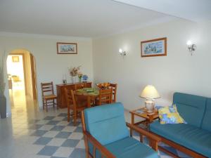 a living room with a couch and a table and chairs at Vilas do Mar in Carvoeiro