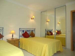 a bedroom with two beds and a mirror at Vilas do Mar in Carvoeiro