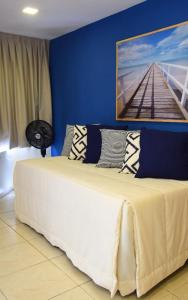 a bedroom with a large bed with a painting on the wall at Ana marinho flat 702 in Natal
