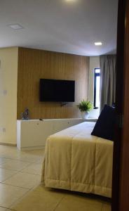 a bedroom with a bed and a flat screen tv at Ana marinho flat 702 in Natal