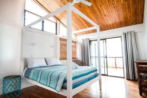 ein Schlafzimmer mit einem weißen Bett und einer Holzdecke in der Unterkunft Beach Buoys in Point Lookout