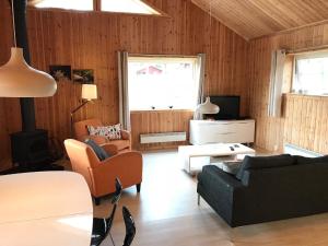 Gunsjögården的住宿－Chalet in Torsby Municipality Middle with Sauna，客厅配有沙发、椅子和电视