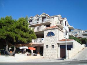 a large building with an umbrella in front of it at Villa Adagio Apartments in Sumartin