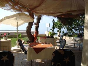 a table with chairs and umbrellas on a patio at Villa Adagio Apartments in Sumartin