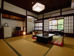 a living room with a table in a room at Ryoso Kawaguchi in Miyajima