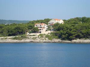 a house on the shore of a body of water at Villa Adagio Apartments in Sumartin