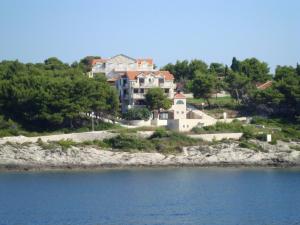a large house on a hill next to the water at Villa Adagio Apartments in Sumartin