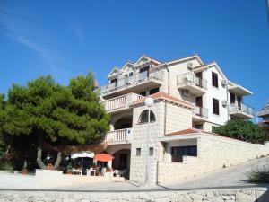 a large building with a tree in front of it at Villa Adagio Apartments in Sumartin